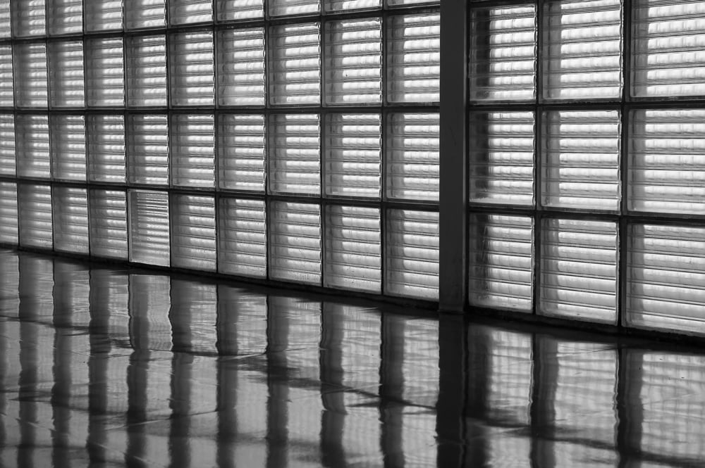 Wall of opaque window panes and reflections on linoleum floor Wall of opaque window panes and reflections on linoleum floor